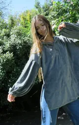 Buzo tipo canguro oversize de plush color verde militar, con capucha, mangas abullonadas con puños elásticos, bolsillo frontal tipo parche y cordón de ajuste en el ruedo. Presenta bordado en el pecho.