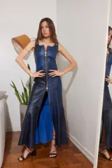 Vestido largo azul con efecto tie-dye, confeccionado en cuero vintage con accesorios dorados. Presenta cierre frontal con cremallera dorada que se extiende hasta el ruedo, y abertura en la pierna.