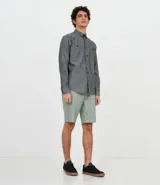 Camisa de manga larga gris con textura, cierre con botones, cuello clásico y bolsillo en el pecho.