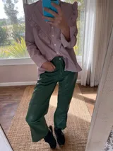 Pantalón slouchy de cuero ovino color verde inglés, corte mom fit con tiro semi alto y tajos inferiores.