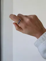 Anillo de acero quirúrgico con diseño de ojos turcos intercalados con pequeñas piedras brillantes.