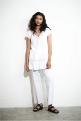 Vestido blanco con escote en V y detalles de vainillas en el escote y en el ruedo.