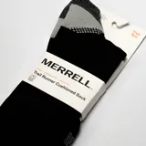 Medias deportivas negras para trail running, con amortiguación media, refuerzos en gris en el talón y la puntera, compresión en el arco y detalles de la marca en naranja en el elástico superior.