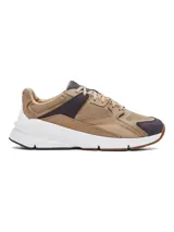 Championes Under Armour modelo Forge 96 Reissue, con diseño inspirado en los años 90. Presenta una combinación de tonos tierra, beige y detalles en marrón oscuro, confeccionados con una parte superior de malla y cuero nobuk. Incluye una entresuela blanca gruesa para mayor amortiguación y una suela exterior de goma.