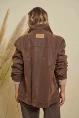 Campera de cuero marrón con efecto desgastado, corte oversize, cuello camisero, cierre frontal con botones y bolsillos frontales con solapa.