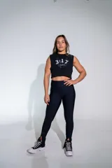 Calza deportiva de tiro alto en color negro, confeccionada en tejido técnico con acabado ligeramente brillante y aberturas en el ruedo.