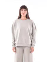 Buzo de cuello redondo color gris claro, de corte holgado y manga larga con puños y dobladillo acanalados.