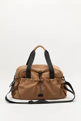 Bolso de nylon en color verde militar, con diseño deportivo, asas de mano resistentes, cierre superior y bolsillos laterales con frunce ajustable mediante cordón elástico.