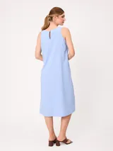 Vestido midi sin mangas de corte recto y holgado, color beige, con cuello redondo y bolsillos laterales.