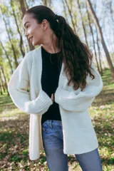 Maxi cardigan color crema de lana merino con bordado de flores rojas y azules.