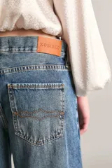 Pantalón de jean tiro medio, wide leg y extra largo, confeccionado en tejido liviano 100% algodón de tono mid blue con sutil localizado.