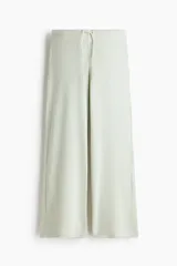 Pantalón de punto color verde menta, de corte holgado y pierna ancha, con cintura elástica y cordón ajustable.