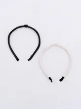 Set de dos tiaras para el pelo, una negra y otra blanca, forradas en cuero sintético.