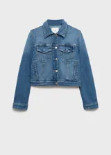 Chaqueta de jean estilo crop, confeccionada en algodón con un toque de elastano, de diseño recto y color azul. Presenta cuello camisero, cierre frontal con botones metálicos, mangas largas con puños abotonados y dos bolsillos de parche con solapa en el pecho.