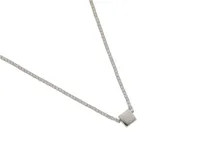 Collar plateado de acero con cadena de eslabones cuadrados y dije central pasante en forma cuadrada.