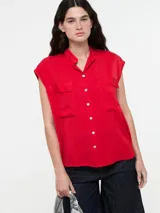 Camisa roja sin mangas con cuello mao, cierre frontal de botones y dos bolsillos funcionales en el pecho.