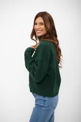 Sweater de punto con cuello alto, manga larga y diseño holgado.
