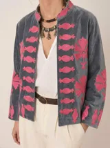 Chaqueta de terciopelo gris con bordados en fucsia de estilo suzani, con cuello mao y diseño abierto al frente.
