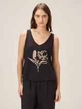 Musculosa de algodón negra con escote en V y detalle de flor bordada en color tostado en el frente.