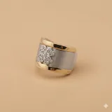 Anillo ancho de plata con bordes de oro y un trébol de circonias en el centro.