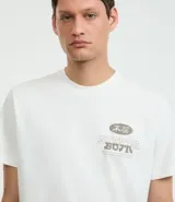 Remera blanca de algodón, corte comfort, con cuello redondo y mangas cortas. Estampa en la espalda con una garza, texto en japonés y la frase "flow like the wind".