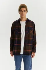 Camisa de franela a cuadros azul marino, marrón y naranja, de corte recto, manga larga, con dos bolsillos frontales con solapa abotonada y cierre frontal con botones.