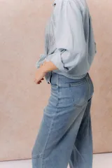 Pantalón de jean de tiro alto, corte culotte y pierna ancha, color azul medio con lavado desgastado.