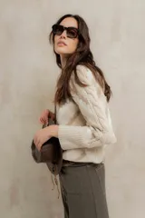 Sweater de punto jacquard con diseño de chevron en tonos celeste y marrón. Presenta cuello redondo, corte holgado y mangas largas con hombros abullonados.