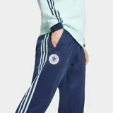 Pantalón deportivo Adidas de la colección Originals, inspirado en la selección de fútbol de Alemania. Es de color azul marino con las icónicas tres tiras laterales en color celeste. Presenta el escudo de la selección alemana en el muslo derecho y un corte clásico con cintura elástica y cordón de ajuste.