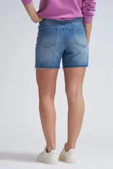 Bermuda de jean azul medio con terminaciones desflecadas.