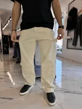 Pantalón cargo de jean oversize en color beige, con bolsillos laterales en las piernas y corte holgado.