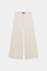 Pantalón de tiro medio, color negro, confeccionado en tejido satinado con diseño de pierna ancha y cintura elástica ajustable con cordón.