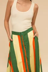 Pollera larga de cintura alta con rayas verticales marrones, negras y verdes. Confeccionada en algodón, con bolsillos laterales y corte evasé.