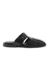 Sandalias tipo mule de cuero negro, con diseño de puntera cuadrada, aberturas laterales y detalle de remaches metálicos decorativos.