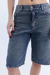 Bermuda de jean tiro alto, color azul con efecto lavado, corte holgado y diseño clásico de cinco bolsillos.
