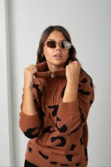 Buzo de tejido de punto con estampado animal print, cuello alto con cierre frontal y mangas largas.