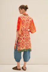 Kimono largo de viscosa con estampado multicolor de estilo étnico. Presenta bordes con detalles geométricos en contraste, mangas anchas y lazo ajustable en la cintura.