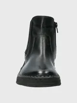 Bota tipo Chelsea de cuero negro, con paneles laterales elásticos y suela de goma flexible con costura vista en el borde.