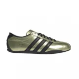 Championes Adidas modelo Tokyo, con acabado metalizado en color dorado y detalles en negro. Presenta las icónicas tres tiras laterales, cordones y suela de goma en color negro.