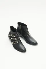 Bota de caña corta confeccionada en cuero vacuno negro. Presenta tres tiras decorativas con remaches metálicos y hebillas sobre la capellada, puntera metálica, cierre lateral interno y taco ancho con detalle de vira metálica.