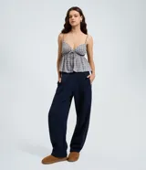 Pantalón de corte barrel en color azul marino, confeccionado en tejido de algodón con felpa. Presenta cintura elástica, bolsillos laterales y detalle de pinzas en la zona de la rodilla para mayor volumen.