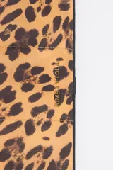 Funda acolchada para portátil de 13,5 pulgadas, con estampado de leopardo y ribetes negros. Presenta un cierre de botón a presión en la solapa y un bolsillo interior doble.