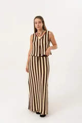 Pollera larga tejida a rayas verticales color chocolate y crema, con pretina elástica y tajos laterales.