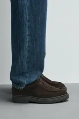 Zapato de cordones con diseño tipo mocasín, confeccionado en piel con acabado de serraje en color marrón. Presenta detalle de costura en el empeine y suela de goma texturizada a tono.