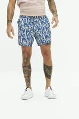 Short de baño con estampado floral en tonos azul y blanco, con cintura fija, cierre de botón y bolsillos laterales.