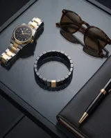 Pulsera elástica compuesta por eslabones de cerámica negra con acabado facetado y una pieza central rectangular con baño de oro.