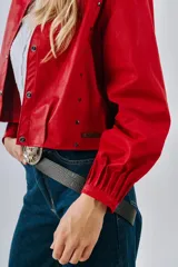 Campera bomber de cuero color marrón, con mangas abullonadas, puños elásticos y cierre frontal con botones a presión.