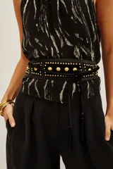 Cinturón tipo faja de cuero vacuno negro, con diseño ancho y decorado con tachas metálicas doradas. Incluye tiras largas con borlas en los extremos para anudar en la cintura.
