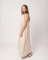 Vestido largo blanco de lino con escote en V y flecos de algodón en los bordes.