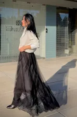Falda larga de tul negro con diseño de capas y terminación en encaje floral en el ruedo.